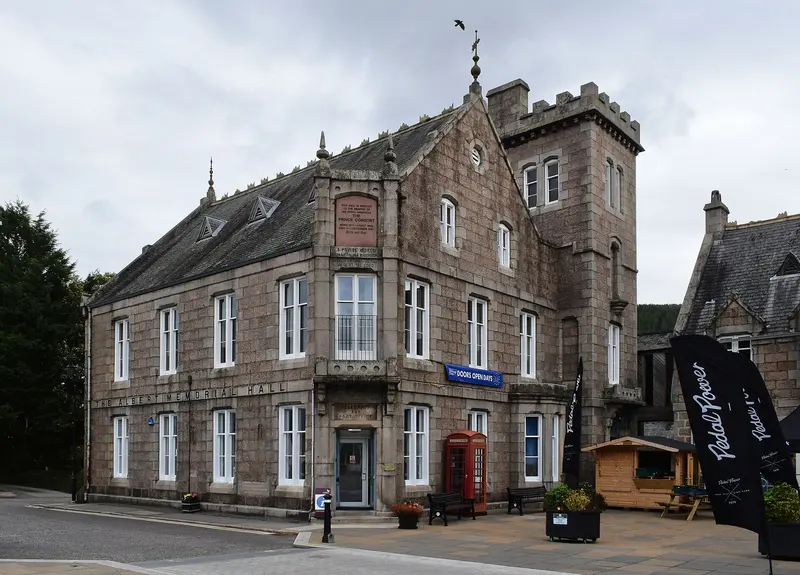 The granite Albert Memorial Hall in Ballater, with its square tower and tall windows, facing a paved square