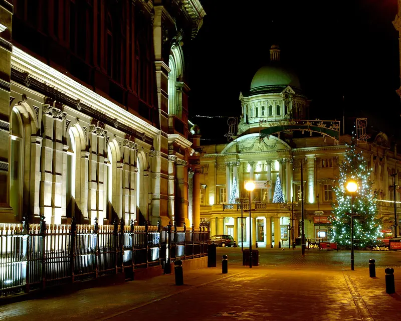 Hull's floodlit Maritime Museum and domed City Hall at night, with a lit Christmas tree and light decorations around Queen Victoria Square